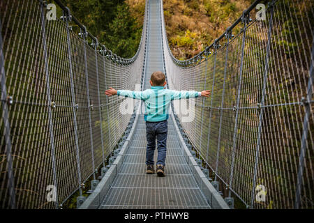 Kid marche sur pont suspendu dans la vallée rabby Banque D'Images