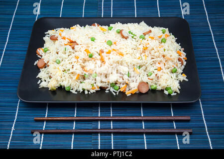 Le riz frit avec des légumes dans un plateau avec des cure-dents Banque D'Images
