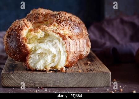 La Challah ou Hala est un sabbat juif traditionnel frais sucré pain, brioche fraîche sur une planche à découper. Pain brioché sur table de petit déjeuner. Le golden Banque D'Images