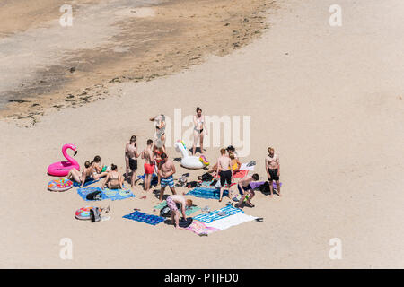 Un grand groupe de jeunes gens s'amuser sur une plage à Newquay en Cornouailles. Banque D'Images