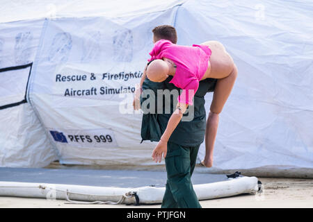 Un paramédic portant un mannequin en vue de participer à un GMICE bonne médecine dans des environnements difficiles incident majeur de l'exercice dans le port de Newquay en Cornouailles. Banque D'Images