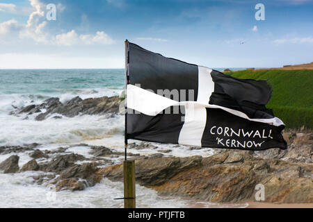 Un drapeau St Piran voltigeant dans le vent sur la côte à Newquay dans Fistral à Cornwall. Banque D'Images