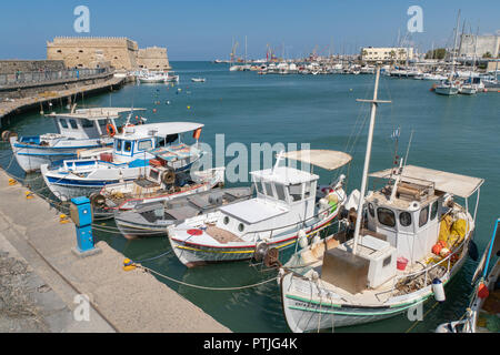 HERAKLION​ HARBOUR - AOÛT 2018 - certains bateaux de pêche sont en attente de leurs équipages. Au loin l'ancien château génois Banque D'Images