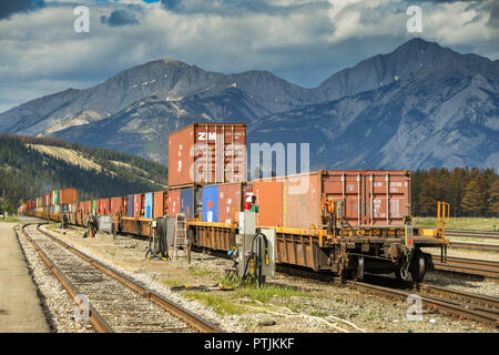 Les wagons de conteneurs sur un lourd train de fret fonctionnant à travers les montagnes au Canada Banque D'Images