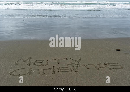 Joyeux Noël et écrit dans le sable sur la plage Banque D'Images