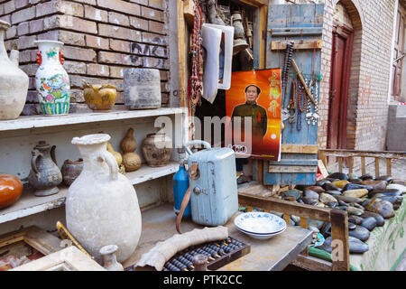 Kashgar, Xinjiang, Chine : un calendrier de Mao Zedong se bloque au niveau de la porte d'un magasin d'antiquités dans la vieille ville. Banque D'Images