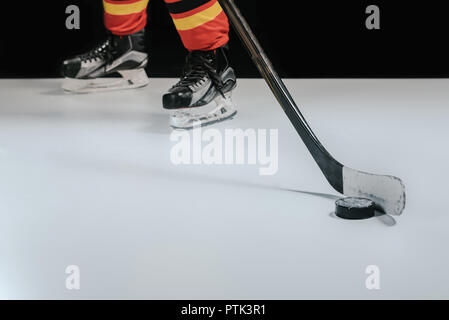 Vue partielle de sportif professionnel jouant au hockey sur noir Banque D'Images