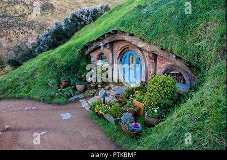 Matamata, Nouvelle-Zélande : Hobbiton movie set créé au film Le Seigneur des Anneaux et Le Hobbit. Chambre avec porte bleue niché dans la colline Banque D'Images