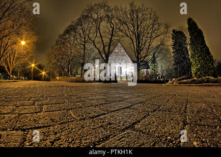 Grand angle faible et la nuit photo de une église entourée d'arbres. Trottoir fait de pierres sur l'avant-plan. Banque D'Images