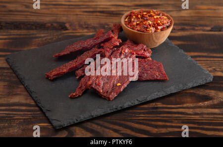 Une Pile de la charque chaude et épicée avec des flocons de piment rouge Banque D'Images