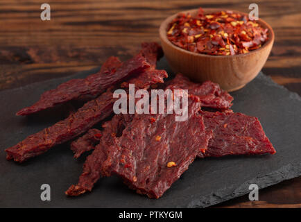 Une Pile de la charque chaude et épicée avec des flocons de piment rouge Banque D'Images