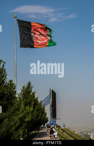 Un immense drapeau de l'Afghanistan vole en haut de colline avec vue sur la piscine de Kaboul. Banque D'Images