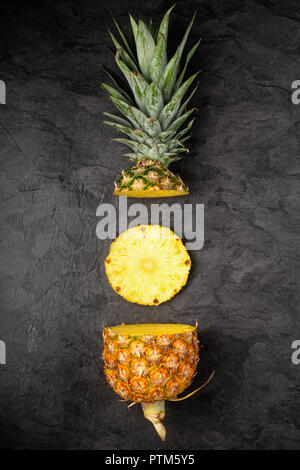 Les sections de l'ananas frais mûrs sur fond sombre, la composition verticale Banque D'Images
