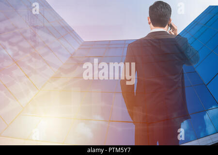 Smart Business homme debout et holding smart phone, double exposition et homme d'affaires, bâtiment téléphone appelant, concept d'entreprise Banque D'Images