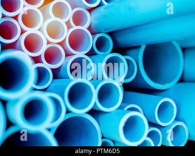 Les tuyaux en PVC Tubes empilés dans l'entrepôt. Les tuyaux en PVC bleu arrière-plan avec la lumière du soleil. Banque D'Images