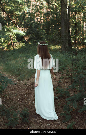 Vue arrière de l'élégante robe blanche fille en balade en forêt Banque D'Images