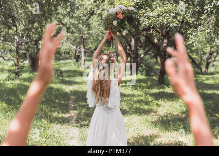 Focus sélectif de belle jeune mariée bouquet de mariage jeter in park Banque D'Images