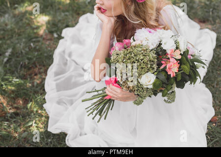 Cropped shot of young bride holding bouquet de fleurs à l'extérieur Banque D'Images