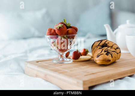 Petit déjeuner délicieux de fraise et croissant sur plateau en bois on bed Banque D'Images