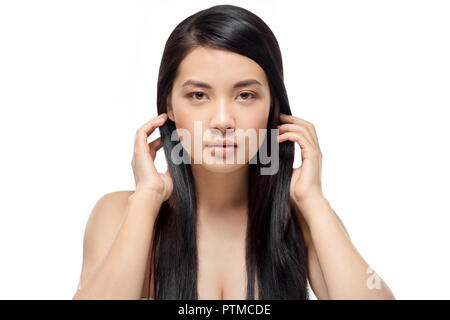 Portrait de jeune modèle asiatique avec des cheveux brillants et sains looking at camera isolated on white Banque D'Images