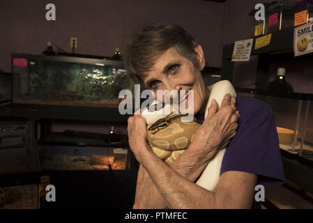 Austell, GA, USA. Août 31, 2018. Diego et Teri Chacon gérer Austell sa propre 'Wild Kingdom' à Animart animaux domestiques. Les spécialistes des animaux de compagnie exotiques à avance manuelle offre bébé oiseaux, reptiles, poissons d'eau douce et d'eau et ont acquis une réputation qui va bien au-delà des frontières d'un etat.Photo : Emma Lackey, la mère de Teri, joue avec Morpheus, et Caramel, deux de la superficie du magasin plusieurs pythons. Crédit : Robin Rayne Nelson/ZUMA/Alamy Fil Live News Banque D'Images