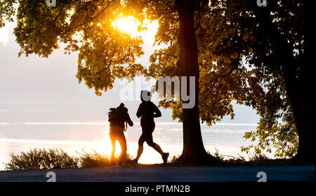 Hanovre, Basse-Saxe. 10 Oct, 2018. Un jogger et un photographe profitez d'une matinée ensoleillée d'automne à le Maschsee. Credit : Julian Stratenschulte/dpa/Alamy Live News Banque D'Images