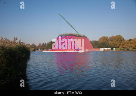 London UK. 10 octobre 2018. Les membres de démanteler le mastaba Londres sculpture flottante temporaire par Christo et Jeanne Claude sur le lac Serpentine qui se composait de 7 506 tonneaux empilés horizontalement qui s'inspire de la sépulture en forme de trapèze des tombes dans l'Egypte ancienne : Crédit amer ghazzal/Alamy Live News Banque D'Images