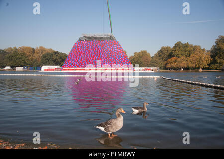 London UK. 10 octobre 2018. Les membres de démanteler le mastaba Londres sculpture flottante temporaire par Christo et Jeanne Claude sur le lac Serpentine qui se composait de 7 506 tonneaux empilés horizontalement qui s'inspire de la sépulture en forme de trapèze des tombes dans l'Egypte ancienne : Crédit amer ghazzal/Alamy Live News Banque D'Images