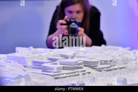 Iéna, Thuringe. 10 Oct, 2018. Une jeune femme photographie un modèle en plâtre de la conception choisie pour une nouvelle, de haute technologie intégrée à Iéna complexe et est présenté lors d'une conférence de presse de Carl Zeiss AG. L'entreprise a un projet d'investissement de plus de 300 millions d'euros. Crédit : Martin Schutt/dpa-Zentralbild/dpa/Alamy Live News Banque D'Images