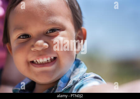 Beau jeune garçon avec un grand sourire et un ensemble complet de dents de bébé à l'extérieur en été excité Banque D'Images