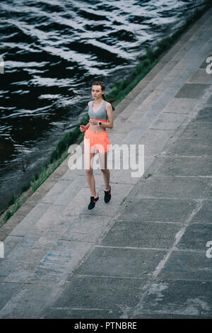 Les jeunes de la sportive le jogging sur le quai près de la rivière Banque D'Images