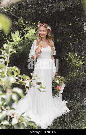 High angle view of beautiful smiling young bride holding bouquet de mariage et d'un verre de vin dans la région de park Banque D'Images