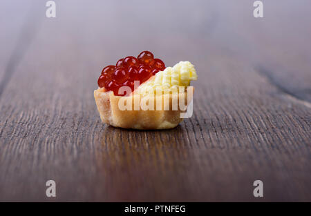 Avec tartelette au caviar rouge et le beurre sur un fond de bois Banque D'Images