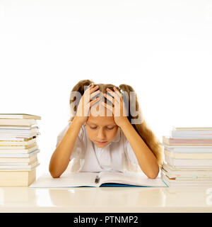 Triste et fatigué cute lycéenne aux cheveux blonds assis dans le stress faire leurs devoirs submerger avec trop d'étude et les manuels scolaires dans l'éducation des enfants académies Banque D'Images