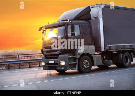 Chariot va sur l'autoroute en soirée sur le coucher du soleil Banque D'Images