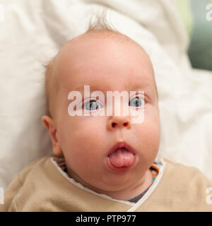 Bebe Avec L Expression Drole Et La Langue Dehors Est Assis Sur Les Genoux De Mere Photo Stock Alamy