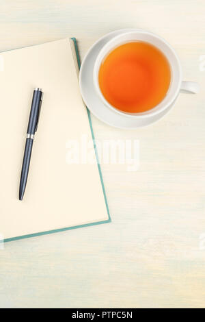 Une photo prise à la verticale d'un journal avec un stylo et une tasse de thé, en plongée des with copy space Banque D'Images