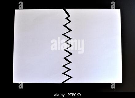 Concept de divisé ou séparé en deux feuilles de papier déchiré. Papier blanc déchiré dans la moitié isolé sur fond noir. Vue d'en haut Banque D'Images