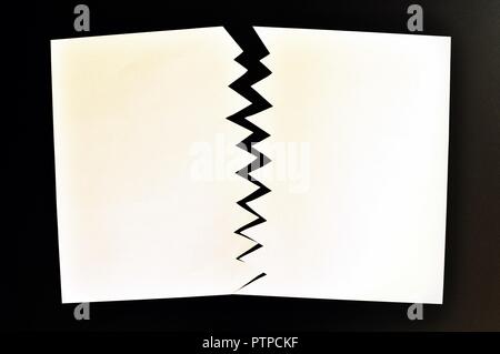 Concept de divisé ou séparé en deux feuilles de papier déchiré. Papier blanc déchiré dans la moitié isolé sur fond noir. Vue d'en haut Banque D'Images