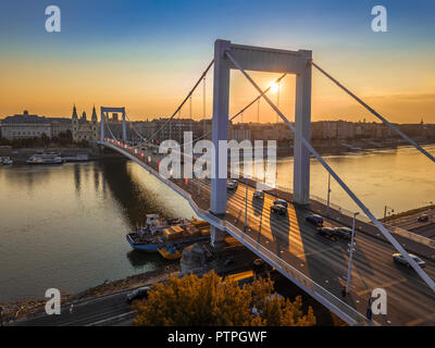 Budapest, Hongrie - Beau Pont Elisabeth (Erzsebet Hid) au lever du soleil avec ciel bleu et d'or, le trafic lourd matin traditionnel et un tramway jaune Banque D'Images