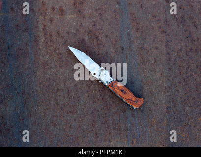 Couteau pliant sur rusty metal background, Close up Banque D'Images