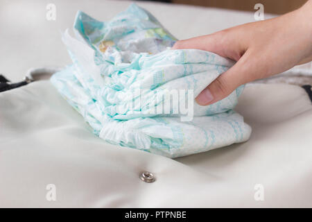 La main féminine détient de couches pour bébés sur un sac, close-up Banque D'Images