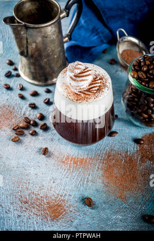 Boisson expresso automne idées, Irish coffee cocktail avec de la crème chantilly et le cacao, le bleu de fond béton copy space