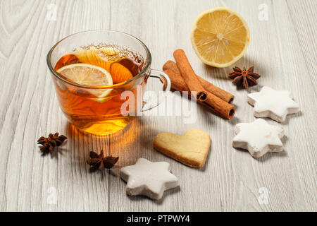 Tasse de thé avec tranche de citron, gingerbread cookies en forme de coeur et d'étoiles et la cannelle, l'anis étoilé sur des planches Banque D'Images