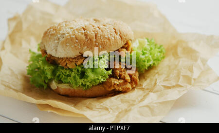 Burger de poulet se trouvant sur parchemin Banque D'Images