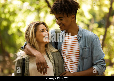 Smiling young couple multiethnique de passer du temps ensemble dans le parc, marcher, hugging Banque D'Images