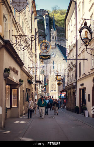 Salzbourg, Autriche - Avril 2015 : la rue historique célèbre Getreidegasse avec de multiples panneaux publicitaires. Banque D'Images