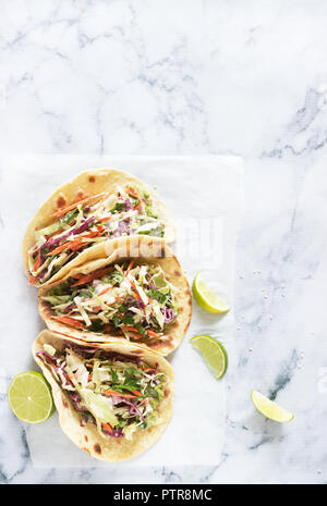 Les tacos de guacamole et servis avec salade de tranches de lime sur un fond clair. Focus sélectif. Banque D'Images