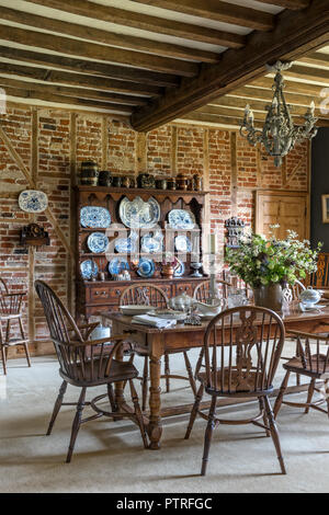 Porcelaine décorative sur meubles anciens en bois commode avec table et chaises dans ferme du 16ème siècle restauré Banque D'Images