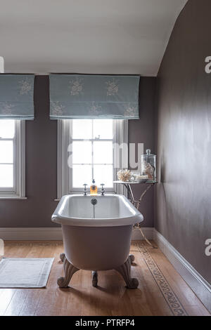 Ferme du 16ème siècle rénovation baignoire sur pieds avec emboidered à rideaux bleu clair dans la fenêtre ferme du xvie siècle restauré Banque D'Images